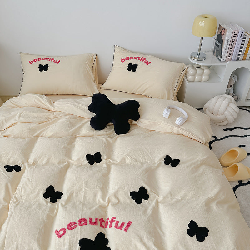 Elegant beige bedding with butterfly embroidery and "beautiful" text