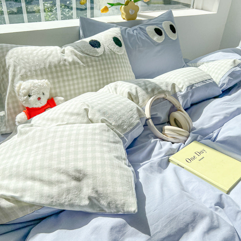 Bedding set with blue gingham pillows and playful eye designs