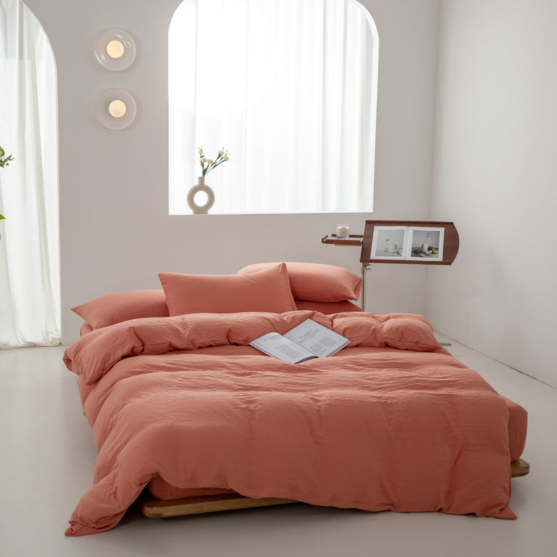 Soft coral pink bedding set with pillows and a book