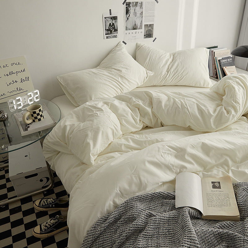 Soft ivory bedding set in a modern bedroom with books and decor