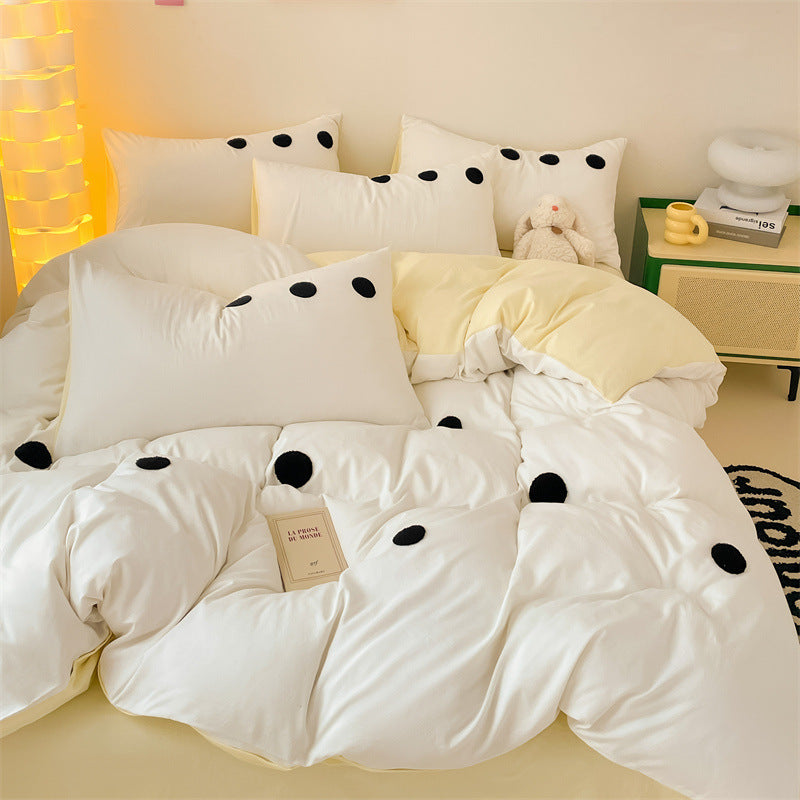 Minimalist white bedding with black dots and yellow pillow accents