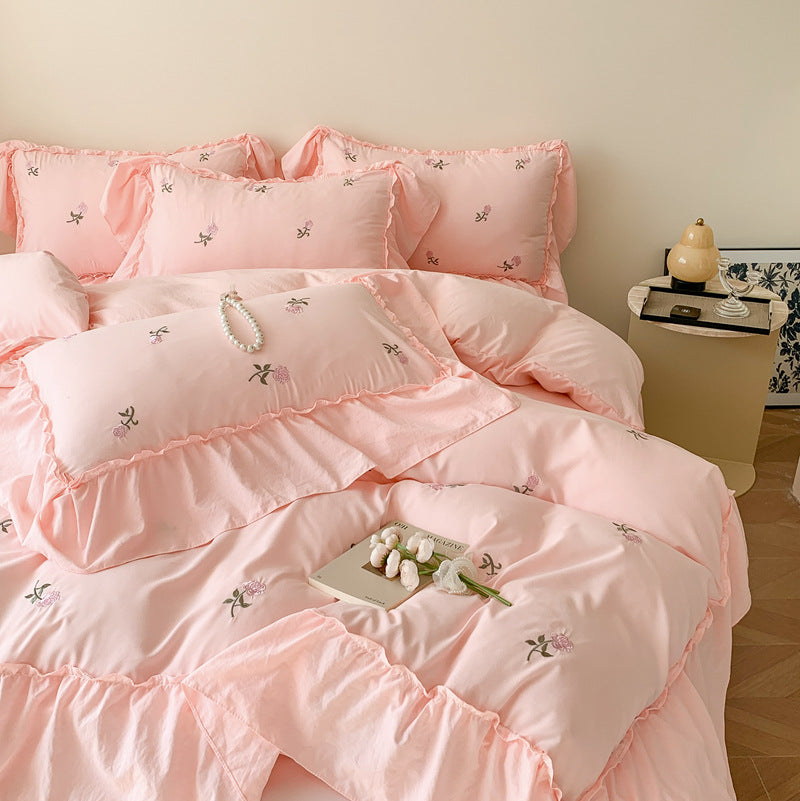 Soft pink bedding with floral embroidery and ruffled edges