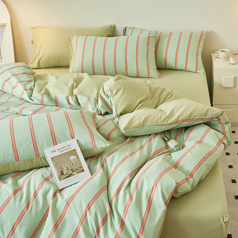 Green bedding set with orange striped pattern and pillows