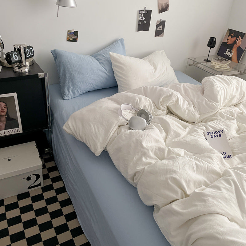 Minimalist white bedding set with blue pillows in a stylish bedroom