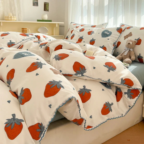 White bedding with a strawberry pattern and blue heart accents